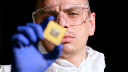 Close up portrait of a young computer engineer with a microchip.
