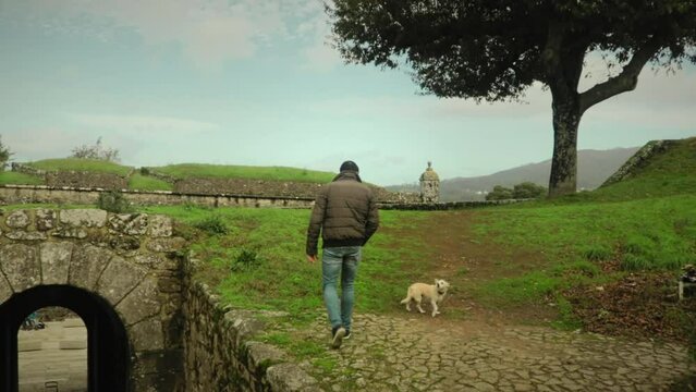 Man and a Dog walk through Ancient Castle Remains