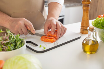 man cuts pepper on  table in  kitchen
