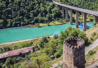 Ananuri, Georgia - July 20, 2015: View of bridge over Arakala river. Walls of Ananuri Castle on foreground