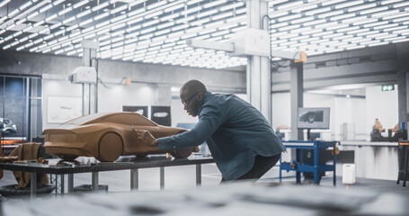African Automotive Designer Using a Spatula to Create a Prototype Car Out of Polymer Modeling Clay....
