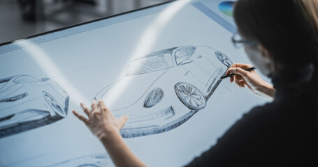 Female Car Designer Using a Digital Tablet to Draw a Prototype Car Sketch with a Stylus. Talented...