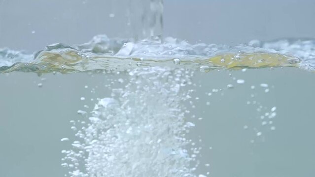 Water falling inside a tub creating splash and bubbles