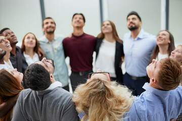 Team of young people hugging in the office.