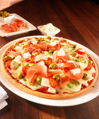 Pizza mit Oliven und Schniken plus Dip in Porzellanschaelchen