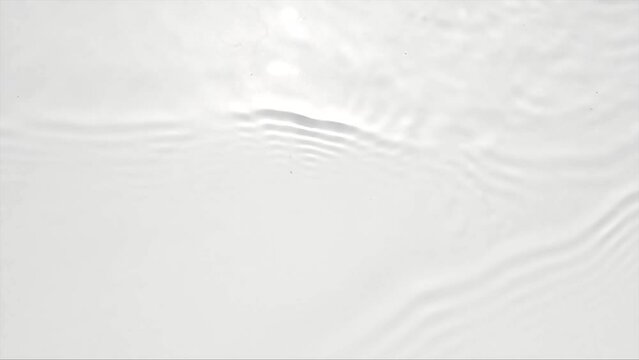 Pure beige water with reflections sunlight in slow motion. Water surface texture top view. Sun and shadows. Motion clean swimming pool ripples and wave.