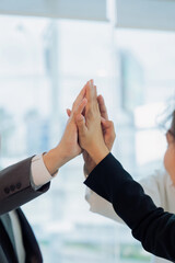 team strategy meeting and high five for team success or achievement at the office.