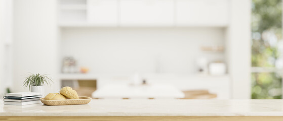 Copy space on a white tabletop over a blurred modern white kitchen in the background.