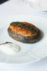 Baked potato with cheese and black caviar
