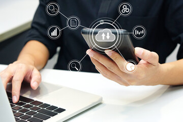 Businessman working with computer and holding smartphone showing multimedia icons virtual. Future technology and hologram business glowing concept.