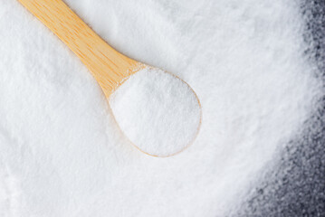 Fototapeta na wymiar White sugar with a spoon on a wooden board, grape sugar, selective focus.
