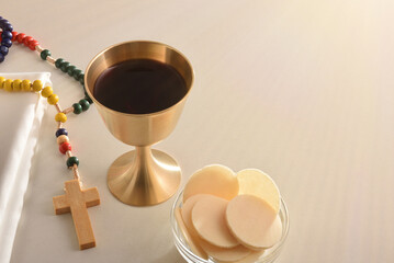 Chalice and consecrated host on table with cross elevated view