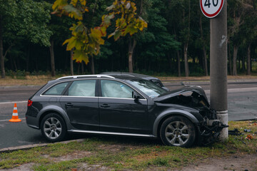 Broken bumper and hood of a car as a result of a collision with a pole, close-up. The car crashed...