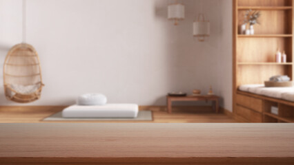 Empty wooden table, desk or shelf with blurred view of minimal zen meditation room with paper doors and resin floor, modern interior design concept