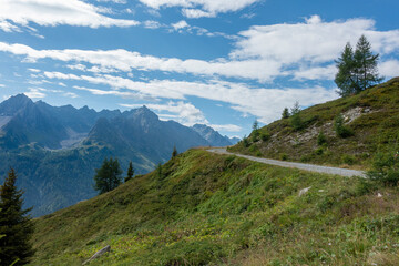 small path in the mountains with view towards alpine summits and sky