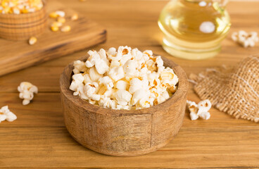 Fototapeta na wymiar Prepared popcorn with ingredients on wooden table