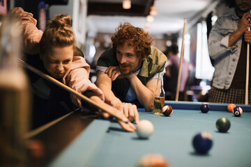Young people playing pool in a club
