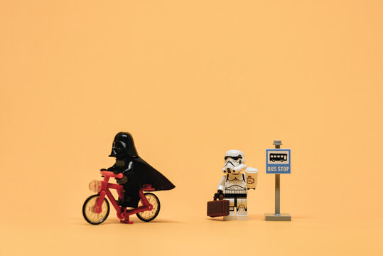 Darth Vader on bicycle passing public bus stop. Public transport concept. Illustrative editorial. September 02, 2021