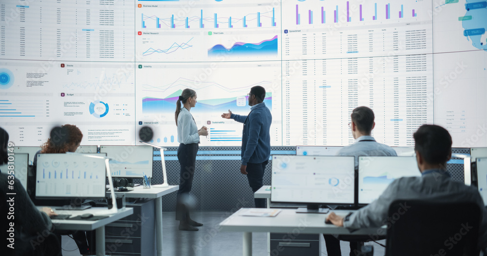 Poster Black Male Financial Data Analysts And Caucasian Female Project Manager Having A Meeting In Monitoring Office With Analytics Feed On Big Digital Screen. Consulting Firm With Employees Behind Computers