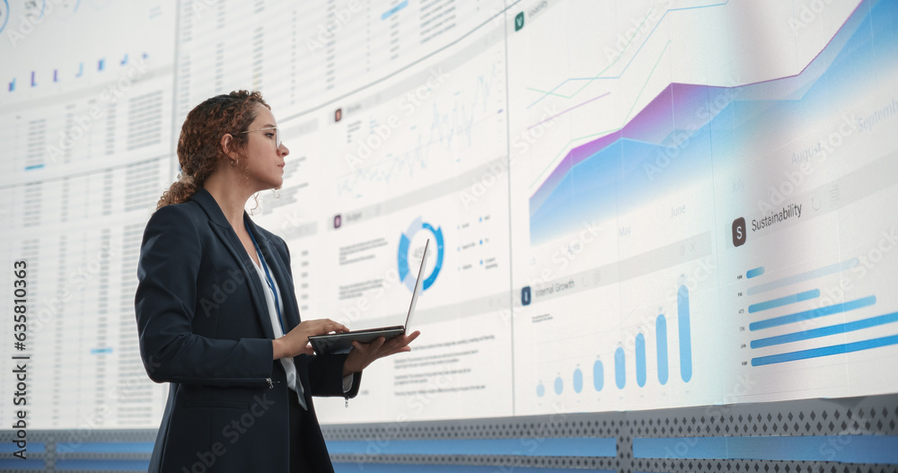 Aufkleber in the monitoring office: successful hispanic businesswoman holding laptop computer and analyzing da