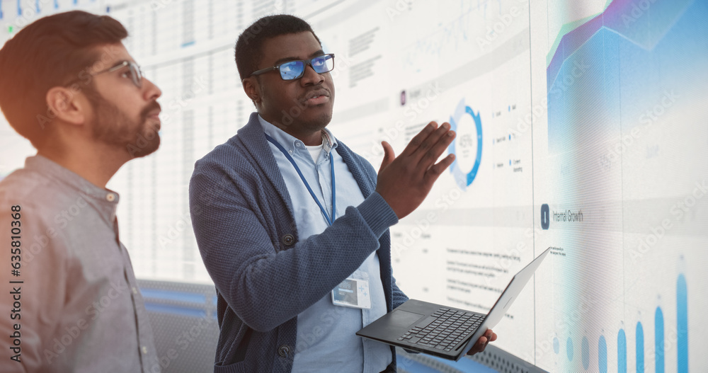 Poster african data science team lead with laptop computer reporting to indian ceo about growth and sales i