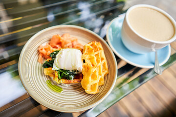 Potato waffles, Poached egg, avocado cream with salmon and egg . Healthy breakfast, protein. Restaurant dish. 