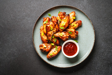 Chicken wings in bbq sauce grilled meat. Restaurant dish. Top view on black stone table.