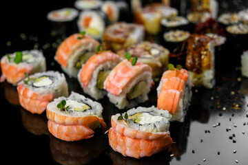Sushi set on a black background. Fresh variety of rolls in a Japanese restaurant. Eastern cuisine.