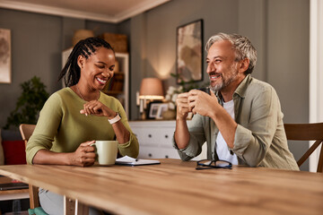 Happy mature couple at home having coffee together.