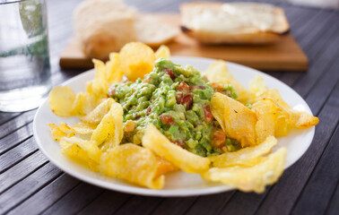 Delicious snack on a plate. Guacamole with chips
