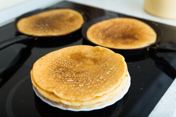 Cooking traditional pancakes from wheat flour in the kitchen