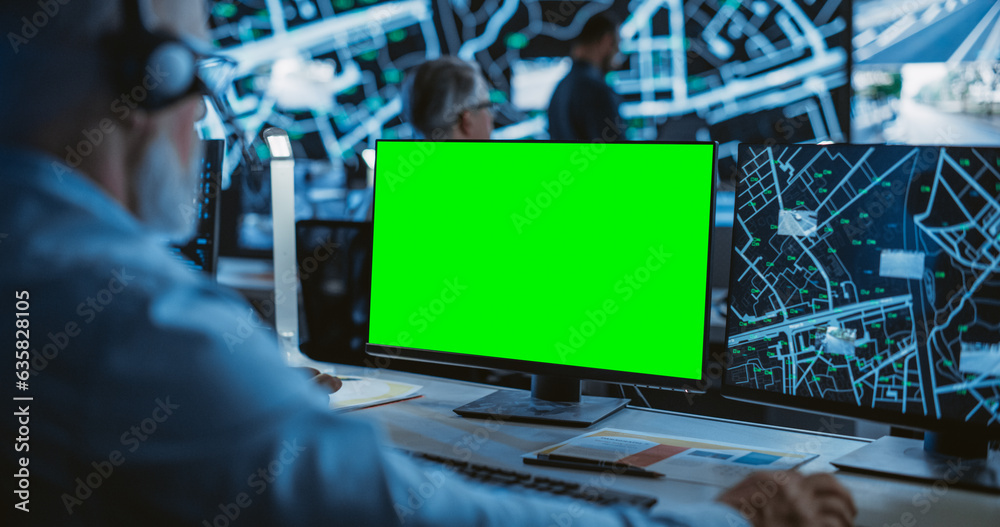 Aufkleber Middle Aged Surveillance Specialist Working on a Computer with Green Screen Mock Up Display. Manager Effectively Multitasking with Supporting Clients on a Phone Call and Computer Work