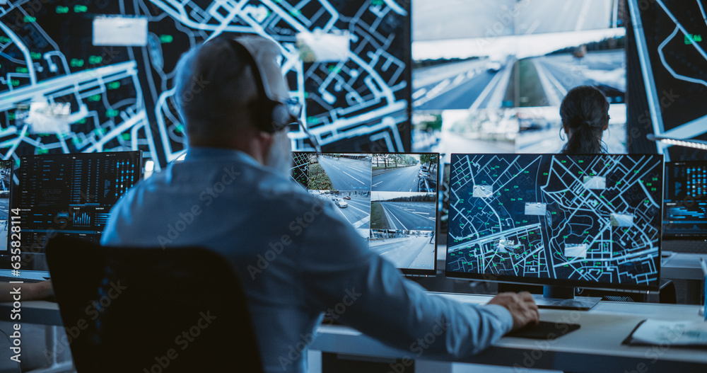 Poster Senior Specialist in a Dark High-Tech Monitoring Room, Concentrated on a Call and Computer Work. Fleet Manager Using Headphones with Built-In Mic for Communication with Delivery Vehicles