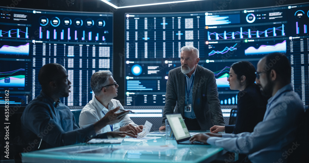 Poster Team Of Data Scientists and Software Developers Discussing Reports in Monitoring Room with Analytics Feed on Big Digital Screen. Senior Man Leading Artificial Intelligence Company Board Meeting