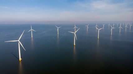 Windmill park in the ocean, drone aerial view of windmill turbines generating green energy electric, windmills isolated at sea in the Netherlands