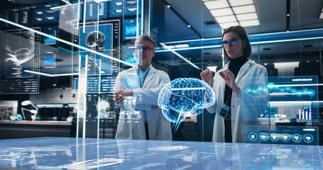 Two Neuroscientists Working With Computer-Powered VFX Hologram Of Human Brain And Nervous System In Futuristic Laboratory. Caucasian Man And Woman Working On Solutions for Brain Damage.