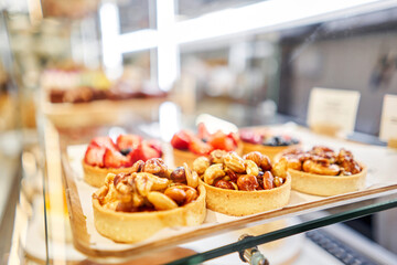 Honey cake with strawberries. fresh pastries with berries. A variety of fresh pastries in the bakery window. Strawberry cake. The interior of an Italian restaurant.