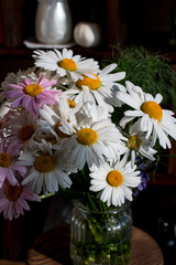 A bouquet of colorful daisies in a vase. Rustic decor, flower shop counter