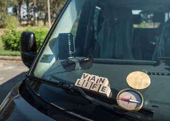 Przednia szyba samochodu wraz napisem VAN LIFE na drewnianych klockach. 