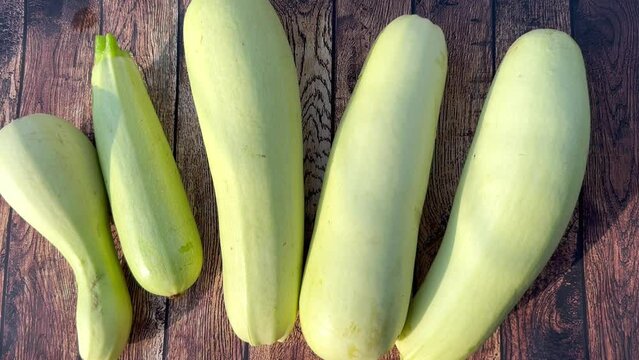 Many zucchini lie on a wooden background