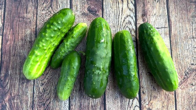 Green fresh cucumbers on a wooden background