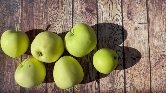Green ripe apples on a wooden background