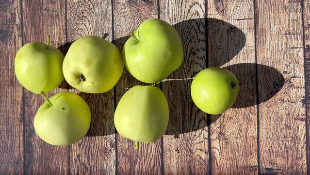 Ripe apples on a wooden table on a bright sunny da