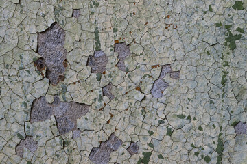 Peeling paint on the wall. Old concrete wall with cracked flaking paint. Weathered rough painted...