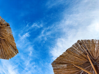 Elements of the tops of beach umbrellas against the sky. Summer still life.