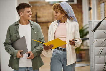 happy interracial business people discussing project, walking in office, holding gadgets, startup