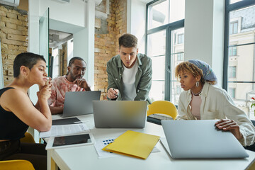 Obraz premium diverse colleagues looking at laptop, working on startup project, ideas and planning, office