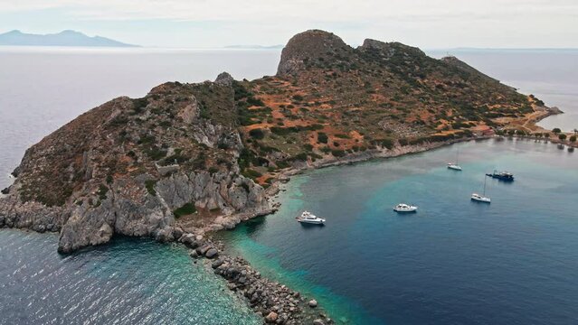 filming from above, aerial view of beautiful, colorful and turquoise sea bay with boats and yachts surrounded cliffs. Mediterranean sea coast, Knidos Ancient city, Datca, Turkey.