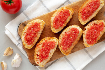 Homemade Pan Con Tomate (Tomato Toast) on a Rustic Wooden Board, top view. From above, overhead, flat lay.
