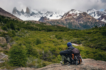 Fototapeta na wymiar Beautiful nature of Patagonia. Man with a backpack observing the view at Fitz Roy trek, view of Andes mountains, Los Glaciers National Park, El Chalten, Argentina